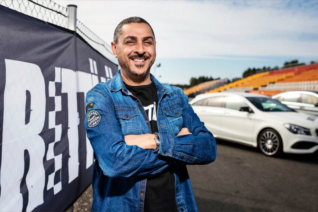 Arman Alizad seisoo kädet ristissä ja hymyilee kameralle.