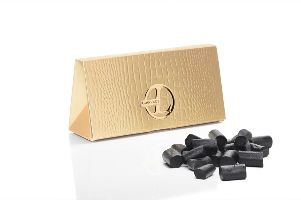 Kultaharkon näköinen pakkaus, jonka kyljessä L-logo sekä teksti "Liquorice". Vieressä kassa lakritsia.