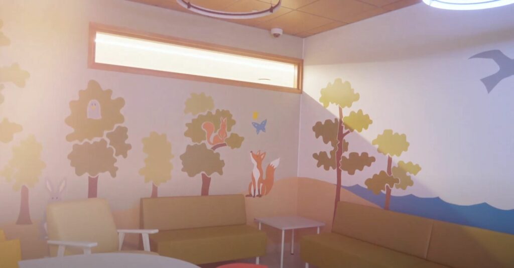 Metsä-aiheinen muraali huoneesta Kymenlaakson sairaalaista Kymsotelle toteutetussa avajaisvideossa.